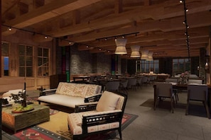 A spacious living area with a sofa, dining tables, and hanging lights. - Taj Gangtey Resort & Spa, Bhutan (Wangdue Phodrang)