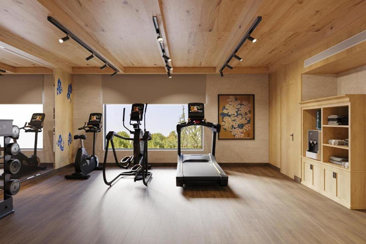 A gym with exercise equipment, a water dispenser, and a large window.