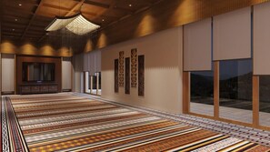 Una habitación amplia con alfombra estampada, un televisor de pantalla plana grande y paneles decorativos en la pared.