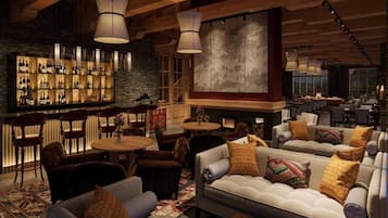 A cozy bar area with wooden beams, a fireplace, and comfortable seating.