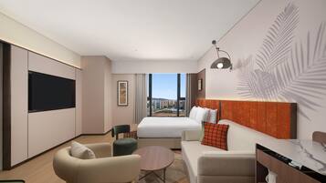 A modern hotel room with a large bed, a sofa, a desk, and a TV.