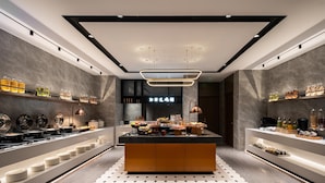Cocina moderna con una isla central, equipada con diversos electrodomésticos y alimentos.