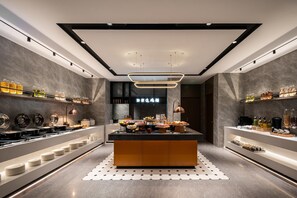 A modern kitchen with a central island, equipped with various appliances and food items. - Homeinn Plus (Beijing)