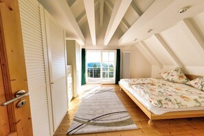 A bedroom with a bed, a window, and a door. - Holiday home with 2 bedrooms (Sasbachwalden)