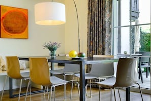A dining area with a table, chairs, and a lamp. - Holiday apartment with 3 bedrooms (Garmisch-Partenkirchen)