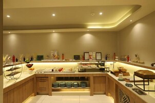 A buffet area with various food items and condiments.