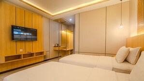 Een moderne hotelkamer met een groot bed, een aan de muur bevestigde televisie en een inbouwkast.