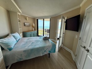 A bedroom with a bed, a television, a wardrobe, and a view of the ocean. - South Tower-10th Floor-2BR/2BA Custom Design & Professionally Decorated-All New! (Myrtle Beach)