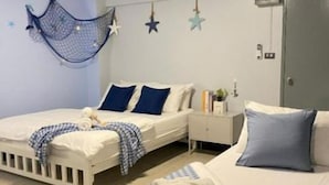 A bedroom with two beds, a bedside table, and a wardrobe. - Triple J Hotel Trang (Trang)