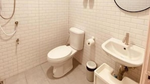 A bathroom with a toilet, sink, and shower. - Triple J Hotel Trang (Trang)