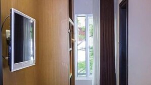 Ein Badezimmer mit einem Holzwaschtisch, einem Spiegel und einem Fenster mit Vorhängen.
