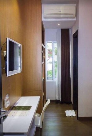 Ein Badezimmer mit einem Holzwaschtisch, einem Spiegel und einem Fenster mit Vorhängen.