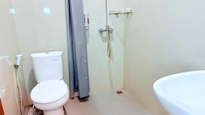 A bathroom with a toilet, a shower, and a sink. - Hotel Kondang Syariah (Harau)