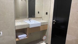 A bathroom with a white sink, mirror, and a black door. - Wilo Hotel Bengkulu (Bengkulu)