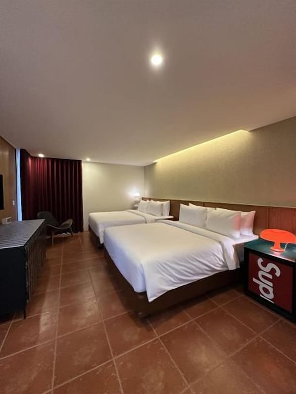 Habitació d'hotel amb dos llits, un escriptori i un minibàr.