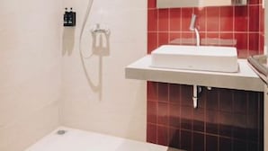 Une salle de bain moderne avec une douche, un lavabo et un miroir.