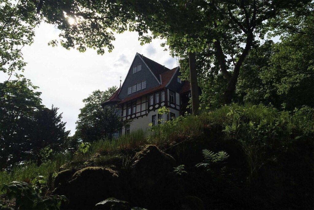 Ein traditionelles Fachwerkhäuschen, umgeben von üppigem Grün.
