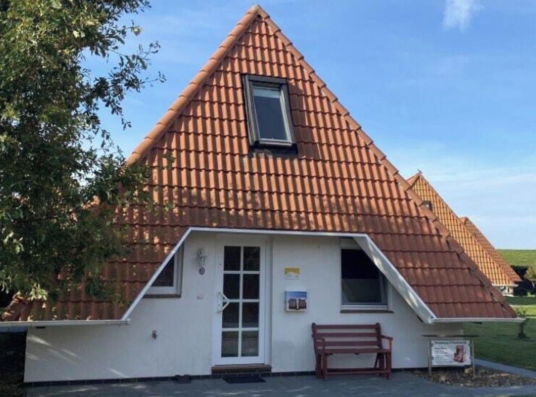 En lille, hvid bygning med et trekantet tag og et enkelt vindue.