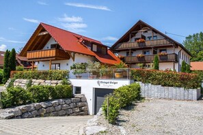 Ein Hotel im traditionellen alpinen Baustil, mit hölzernen Balkonen und einer Steinaußenwand.