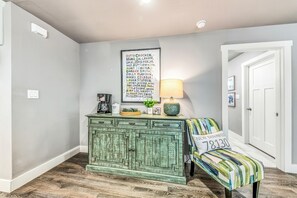 A room with a green chest of drawers, a coffee maker, a lamp, and a chair with a pillow. - Gruene Road Cottage - New Braunfels (New Braunfels)