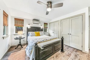 A bedroom with a bed, bedside tables, a ceiling fan, and a wardrobe. - Gruene Guest House - New Braunfels (New Braunfels)