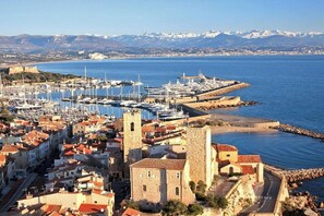 A coastal town with historic buildings, a marina, and a mountainous backdrop. - Holiday apartment with 1 bedroom (Antibes)