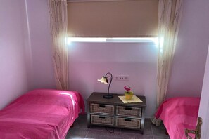 A room with two beds, a bedside table with a lamp, and a window with curtains. - Holiday home in Chayofa with swimming pool (Chayofa)