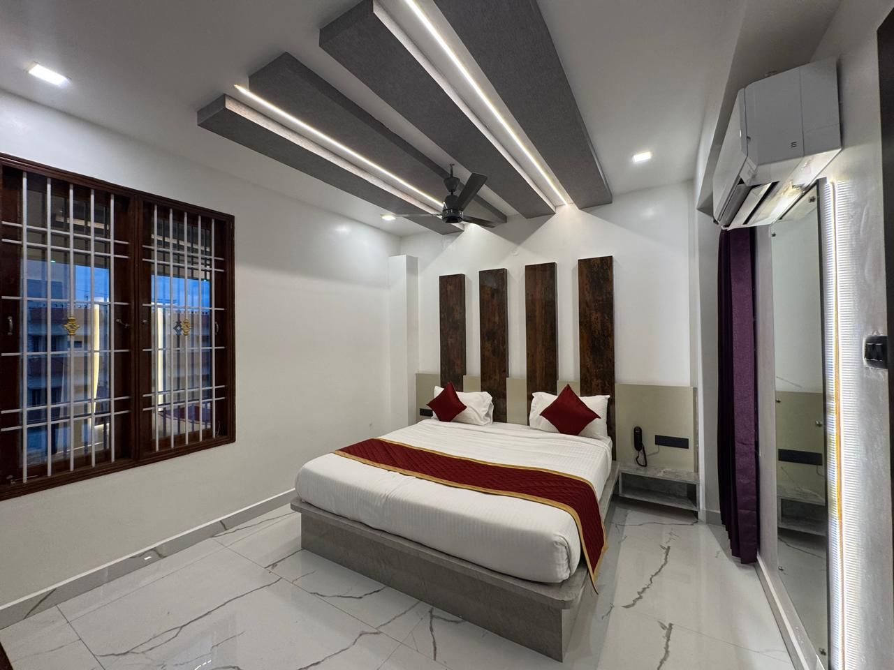 Ein modernes Schlafzimmer mit einem großen Bett, einem Deckenventilator und einer Klimaanlage.