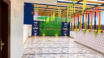 Un pasillo con suelo estampado, pared verde con jardín vertical y techo con plantas colgantes.