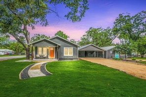 A two-story house with a front porch, a garage, and a well-maintained lawn.