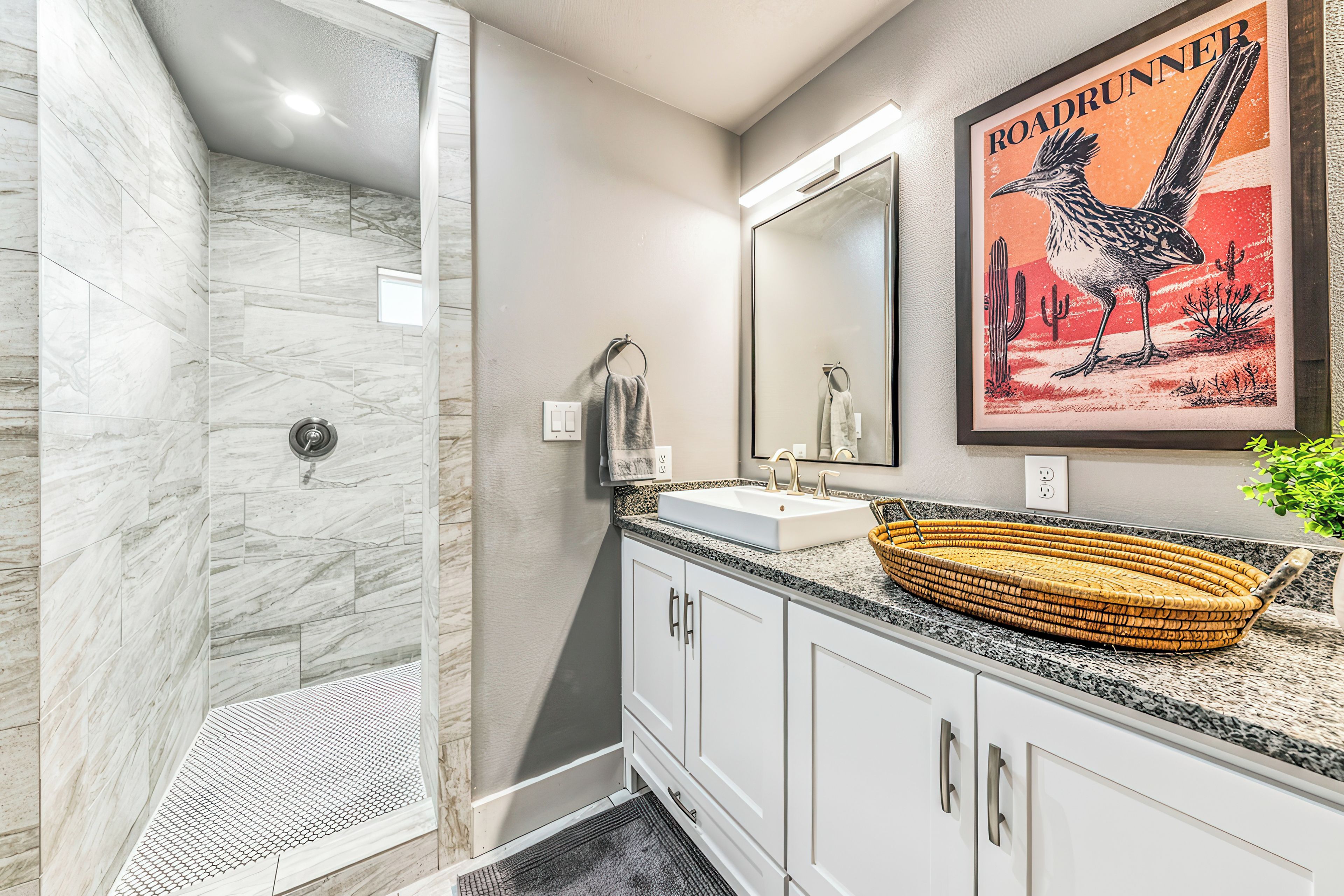A bathroom with a shower, a sink, and a mirror.