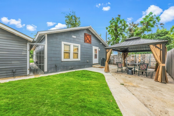A residential property with a covered patio, a well-maintained lawn, and a garage.