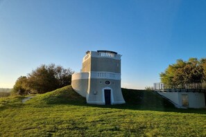 A tower with a circular base and a flat top, surrounded by a grassy area and trees. - Holiday apartment with 2 bedrooms (Gaienhofen-Horn)