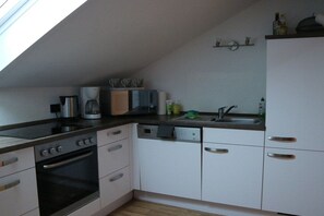 A compact kitchen with a dishwasher, oven, and a coffee maker. - 3 - Nina's Country House (Hohenschwangau)