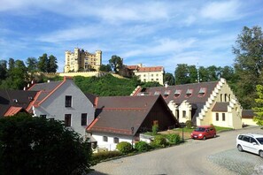 Eine Burg auf einem Hügel mit traditioneller Bebauung im Vordergrund.