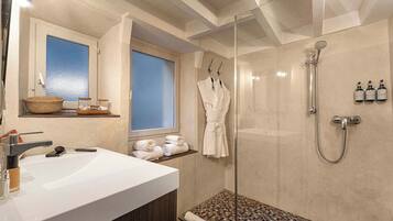 Une salle de bain moderne avec une douche à parois de verre, un lavabo blanc et une fenêtre donnant sur un beau paysage.