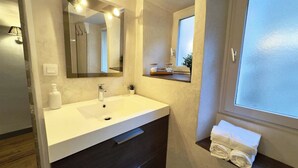 A bathroom with a white sink, mirror, and towel rack. - Room Porcelaine Chambéry (Chambéry)