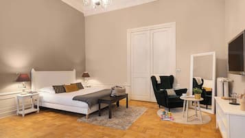 Un dormitorio con cama, mesitas de noche, una silla, escritorio y espejo.