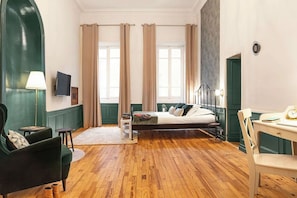 A hotel room with a bed, a desk, a chair, a lamp, and a television. - Chambre Verveine Chambéry (Chambéry)