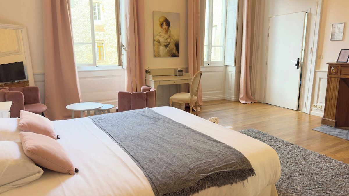 Une chambre d’hôtel avec un lit, un bureau, une chaise, une télévision et un tableau au mur.