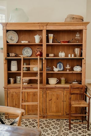 Ein Holzschrank mit mehreren Regalen, der verschiedene Küchenutensilien beherbergt.