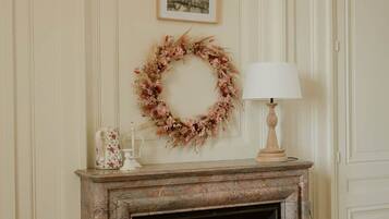 A room with a fireplace, a framed picture on the wall, and a decorative wreath.
