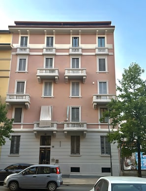 A multi-story building with balconies, a door, and a window with shutters. - Apartment 'Piranesi 45' with Wi-Fi and Air Conditioning (Milano)