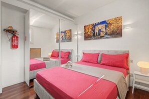 A hotel room with two beds, red bedding, a large mirror, and artwork on the walls. - Apartment 'Piranesi 45' with Wi-Fi and Air Conditioning (Milano)