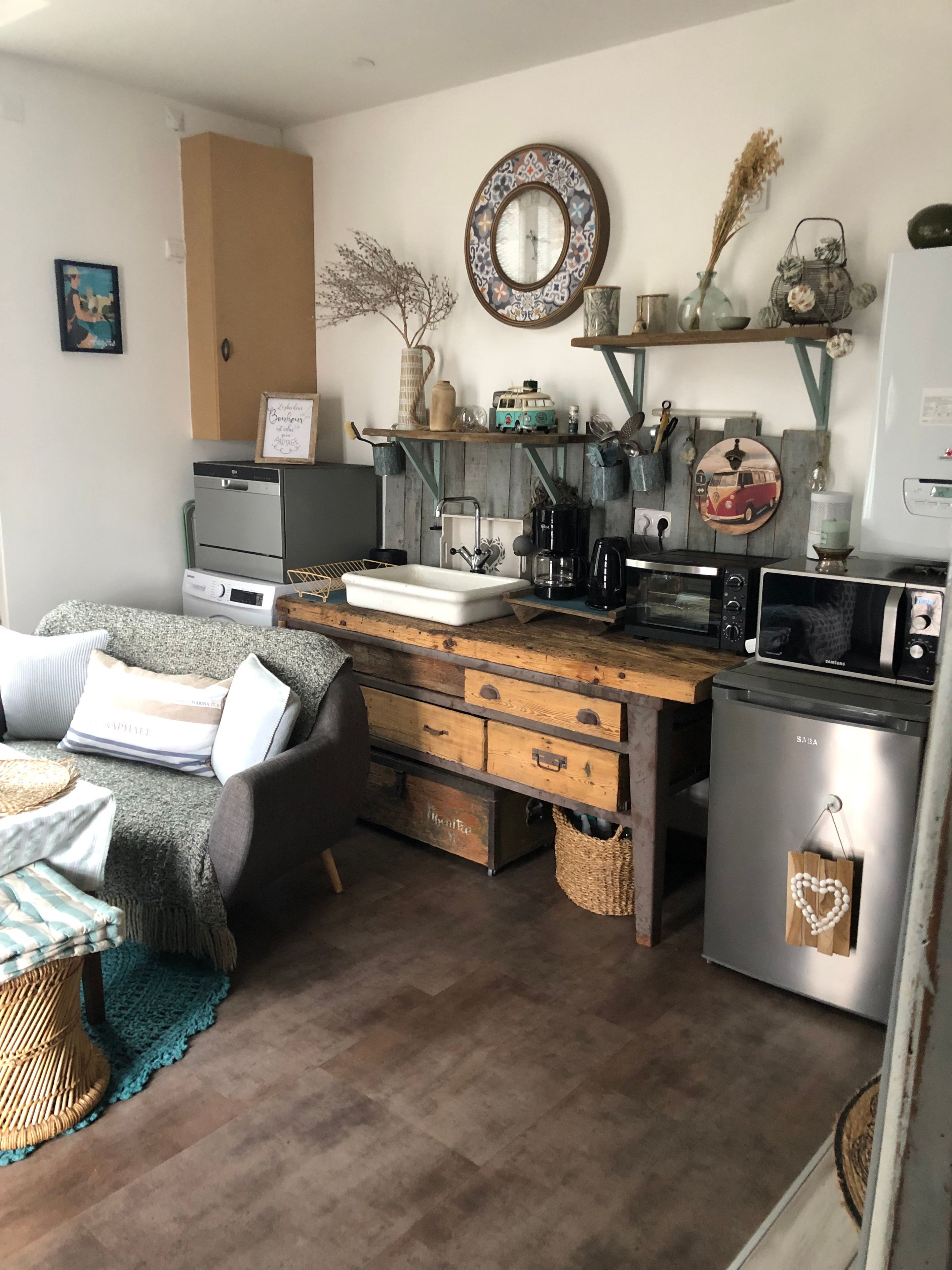A compact living space with a kitchenette, a sofa, a coffee table, and a dining area.