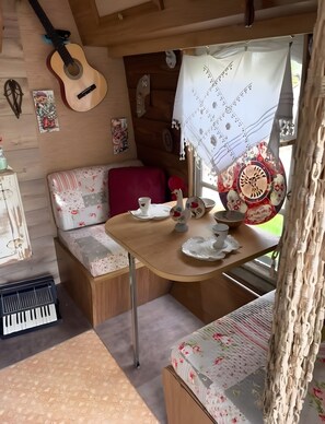 Ein gemütliches Interieur mit einem Holztisch, einer Gitarre und einer Hängematte.