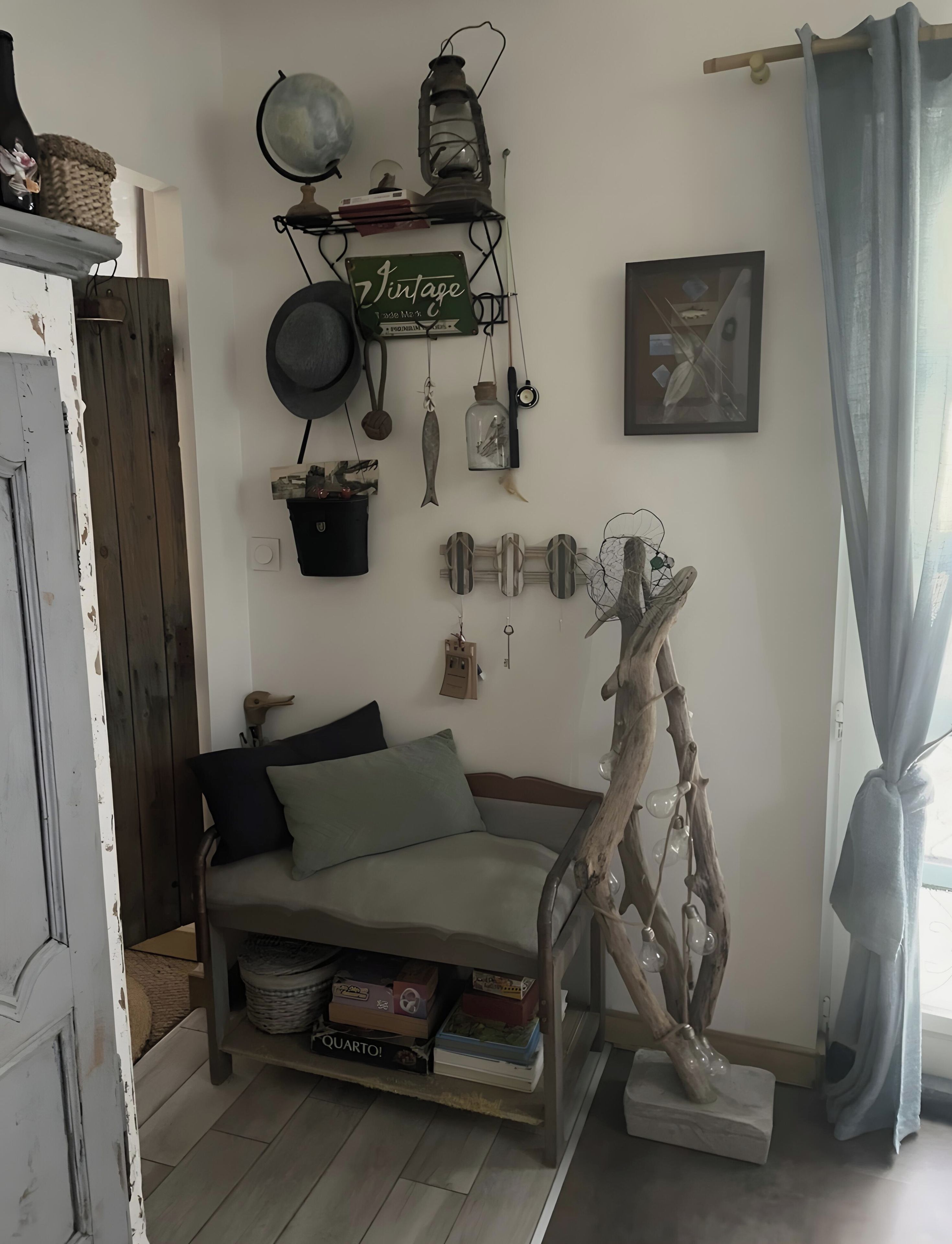 A cozy room with a sofa, a decorative wall hanging, and a rustic wooden sculpture.