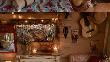 Een gezellig slaapkamer met een bed, kussens, een gitaar, een piano en diverse decoratieve objecten.