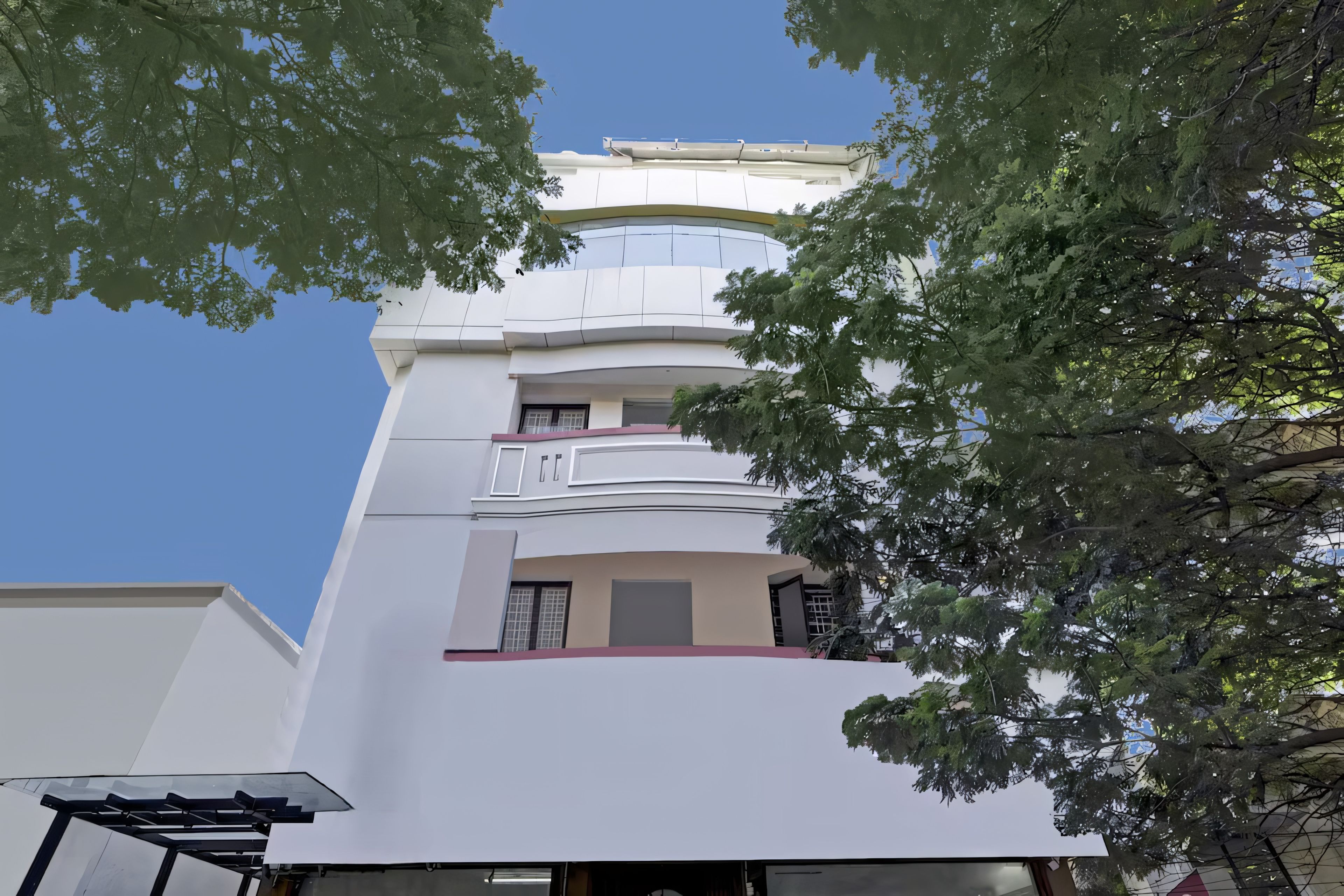 Un immeuble à plusieurs étages doté d’une architecture moderne, avec des balcons et de grandes fenêtres.
