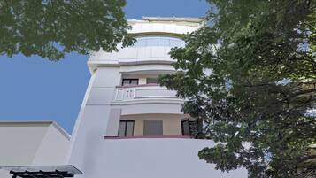 Un immeuble à plusieurs étages doté d’une architecture moderne, avec des balcons et de grandes fenêtres.